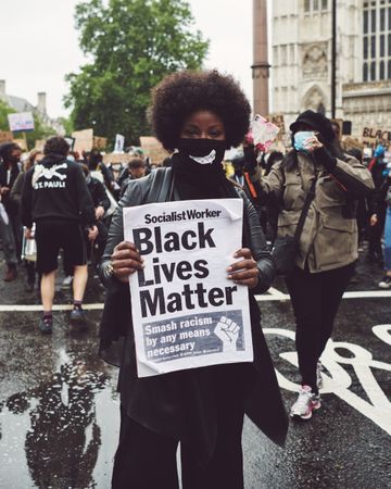 London, England, United Kingdom - June 6th, 2020: Woman in face mask holding Black Lives Matter sign
