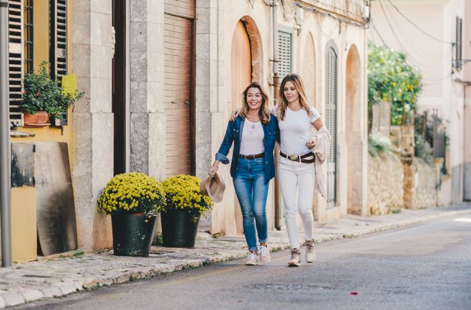 Friends having fun embracing in street