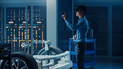 Automotive Engineer Working on Electric Car Chassis Platform, Using Augmented Reality Headset with Touching Gestures.