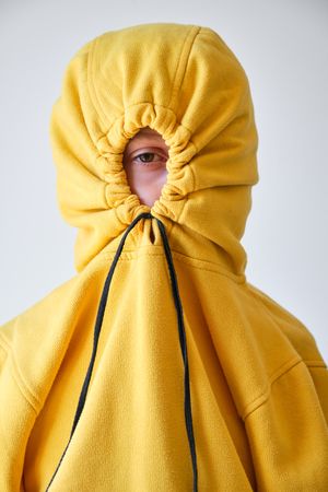 Unrecognizable kid with hood on head in studio