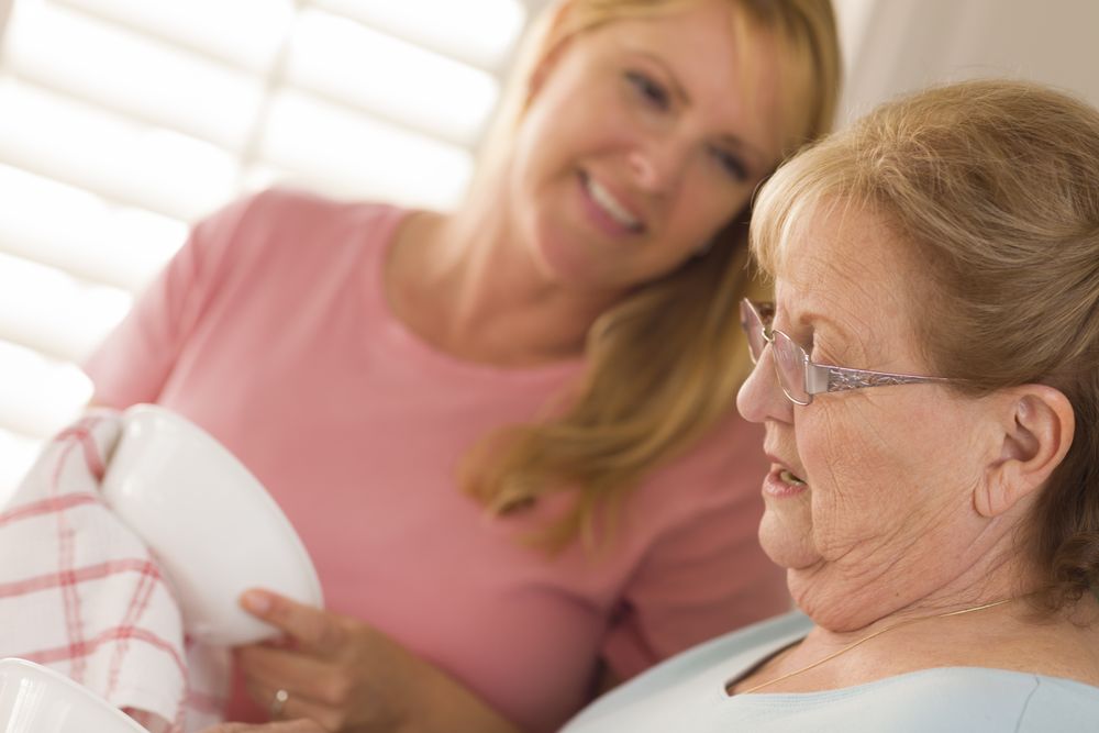 Older Adult Woman and Young Daughter Talking in Kitchen