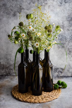Wine bottles vases full of daisy flowers