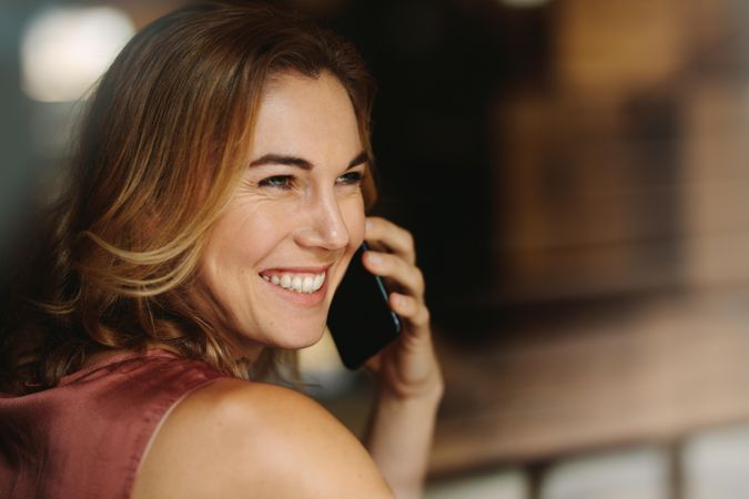 Portrait of a happy woman holding a phone to her ear