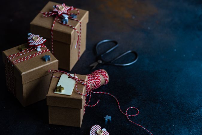 Three brown Christmas gifts with red string with copy space