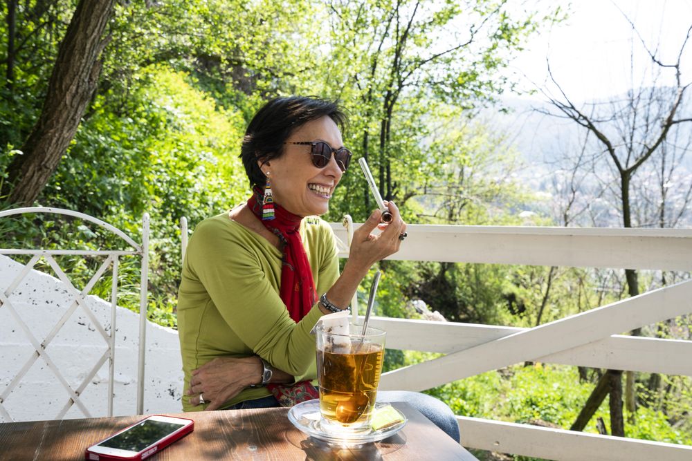 Woman smiling holding a marijuana pipe