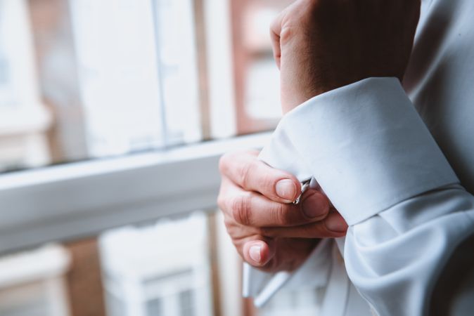 Man buttoning up shirt sleeve