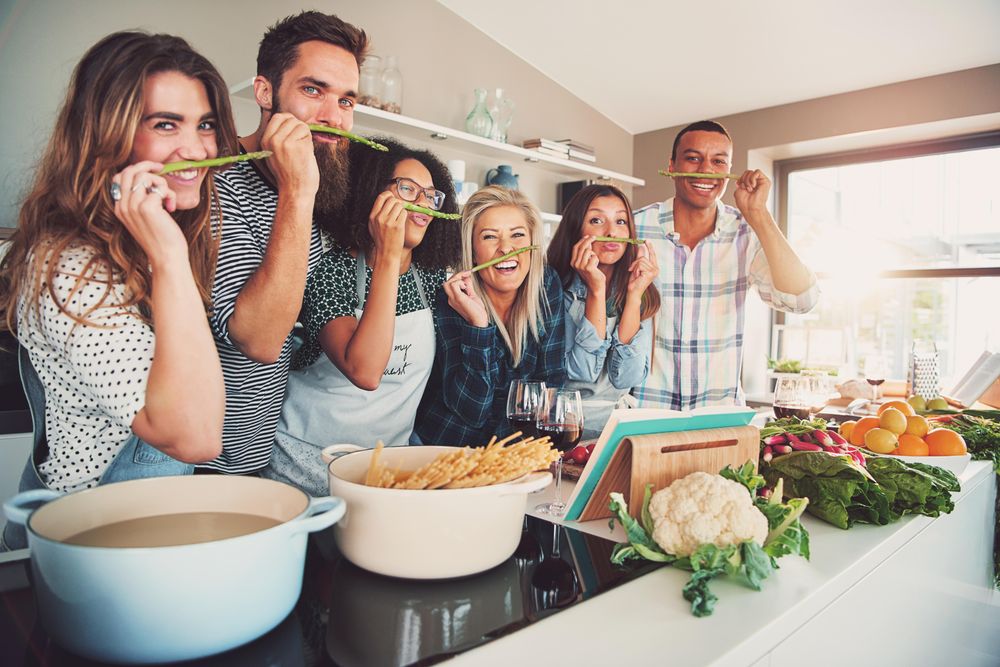Friends laughing and posing with asparagus