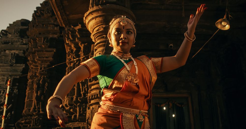 Portrait of Three Expressive Young Indian Dancers Performing Folk Dance Choreography Inside an Ancient Temple.