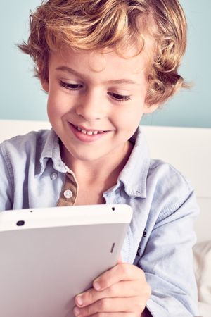 Smiling boy using tablet at home