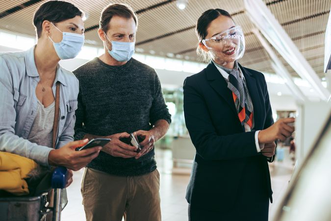 Passenger family helped by airlines attendant at airport in pandemic