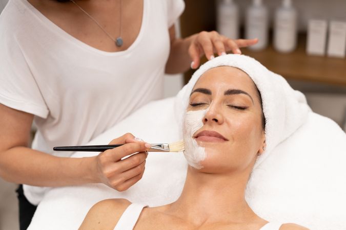 Woman having a relaxing face mask applied at salon