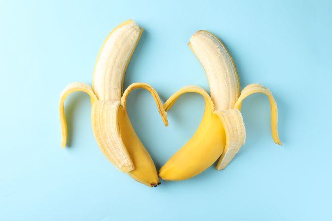 Heart made of bananas on blue background. Fresh fruit