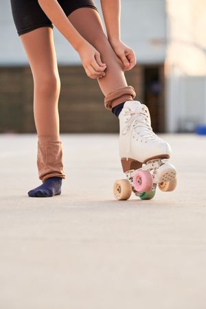 Unrecognizable girl in roller skate preparing for training