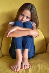 Calm cute girl sitting in comfortable armchair