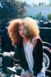 Fashion photo of young Black woman outside in front of pile of tires