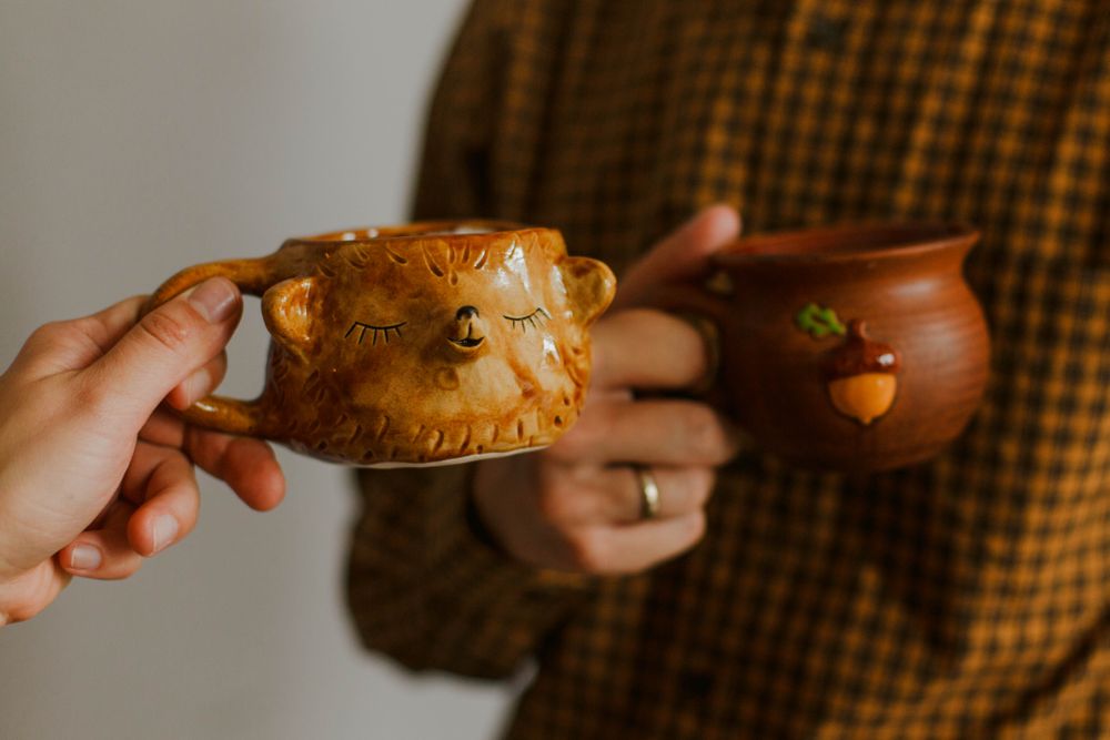 Two people drinking from decorated mug