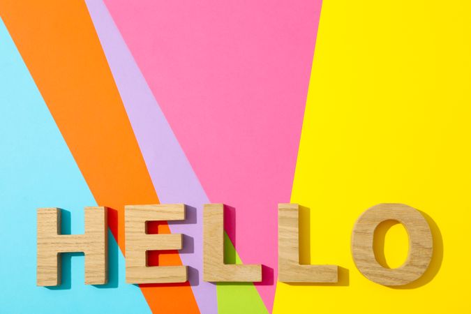 Word Hello lined with wooden letters on multicolor background