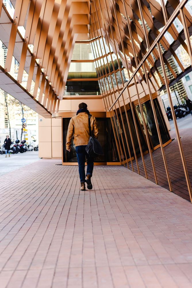 Stylish guy walking outside modern building