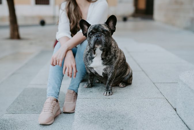 Woman with cute bulldog on street