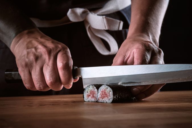 Male shushi man hands preparing different pieces of makis