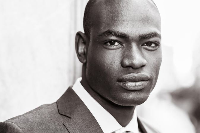 B&W picture of male looking at camera while wearing business attire