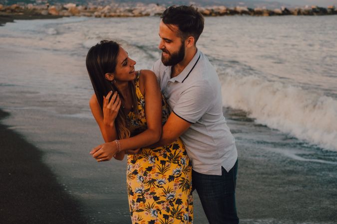 Loving couple embracing happily on sandy beach