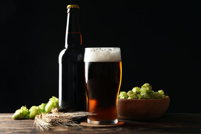 Beer, wheat and hop on wooden table