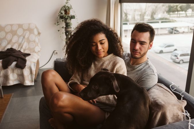 Multiethnic couple with dog on couch