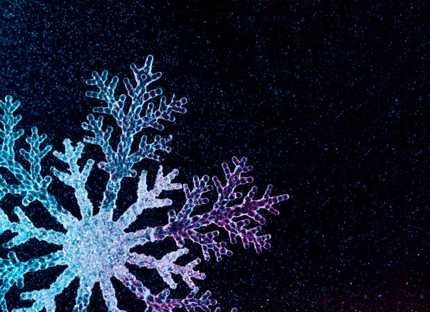 Snowflake in vivid neon colors on dark background