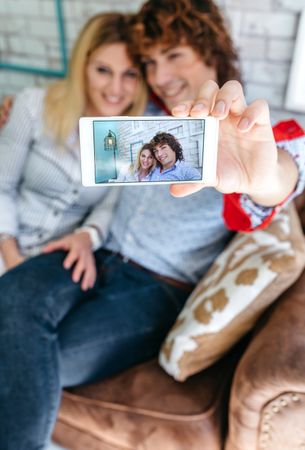 Top view of couple taking selfie on a sofa