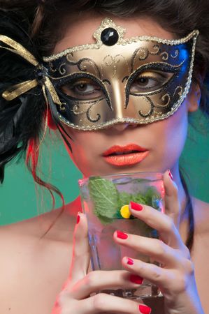 Woman in mask holding glass of drink