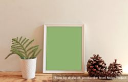 Rectangular picture frame with green interior mockup with pinecones and branch in vase 4MVQyb