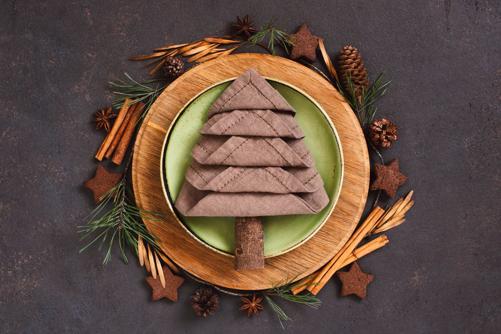 Holiday table setting with napkin in the shape of a tree, and wreath