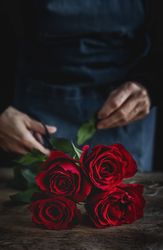 Unrecognizable woman making a bouquet of red roses