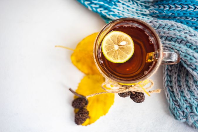 Top view of autumnal tea with lemon slice and decorative pine cones