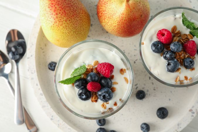 Parfaits and pears on wooden table, space for text