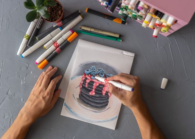 Person drawing painting a layered pancakes with fruits