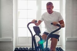 Man on exercise bike in bright room