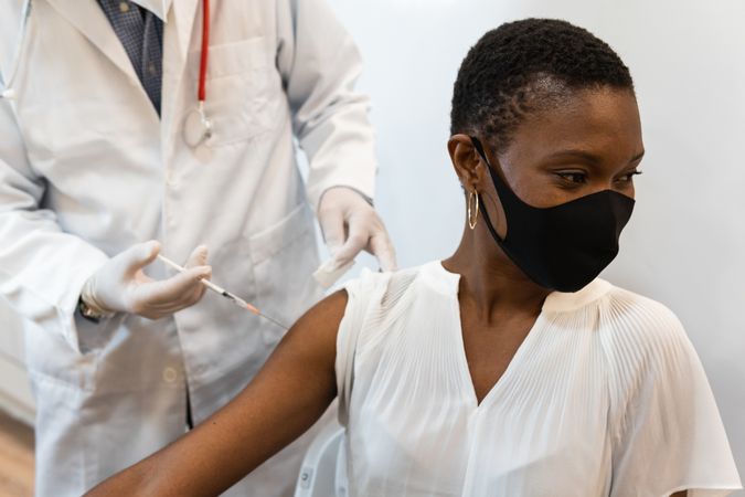 Doctor making injection for Black woman patient