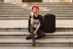Cheerful tourist drinking on steps