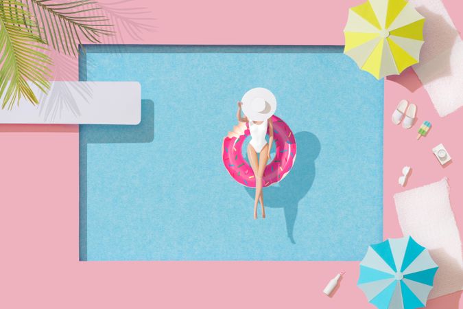 Barbie-like doll in donut ring in pool, with poolside parasols and towels