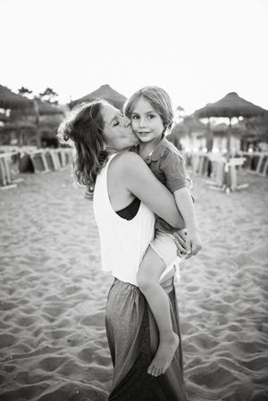 Mother kissing son on beach