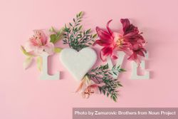 “Love” written on pink background with spring flowers 0LP3e0