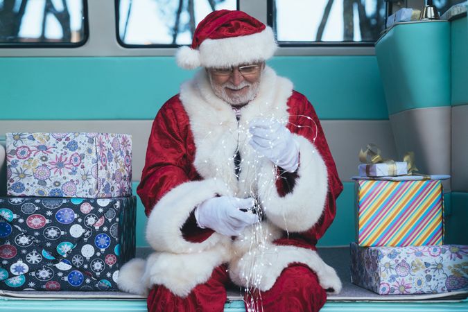 Santa Claus sitting with gifts and garland
