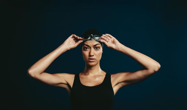 Professional female swimmer on dark background