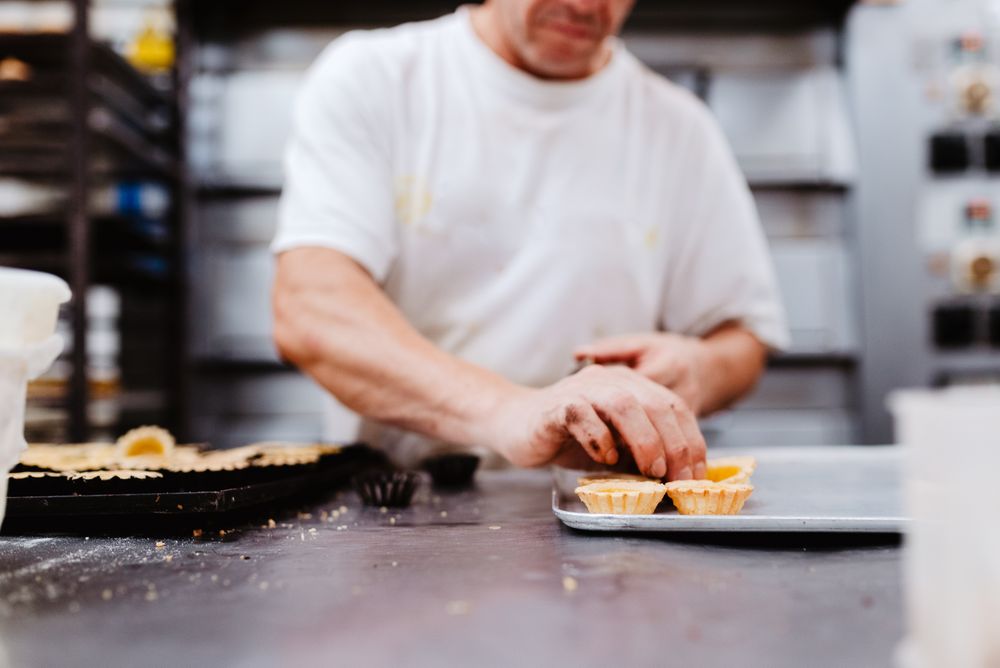 Crop confectioner decorating small cakes
