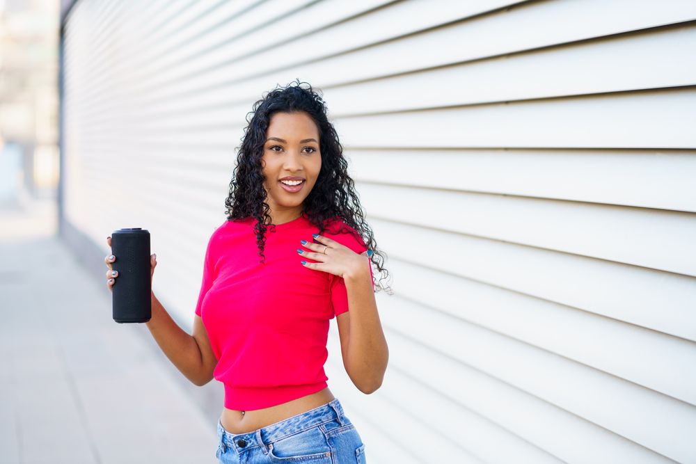 A Confident Woman Posing with a Drink in Hand Against a Stylish Modern Background Setting