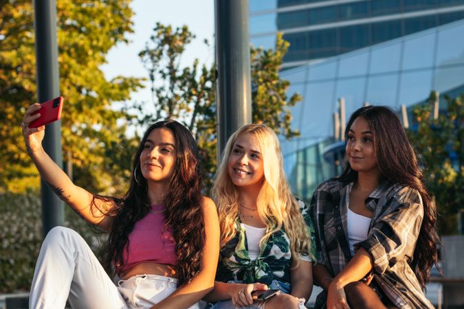 Female friends taking selfies outdoors