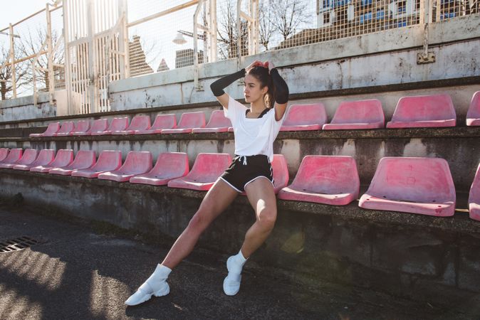 Young sportswoman resting on shabby seat