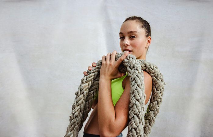 Female model athlete holding battle rope